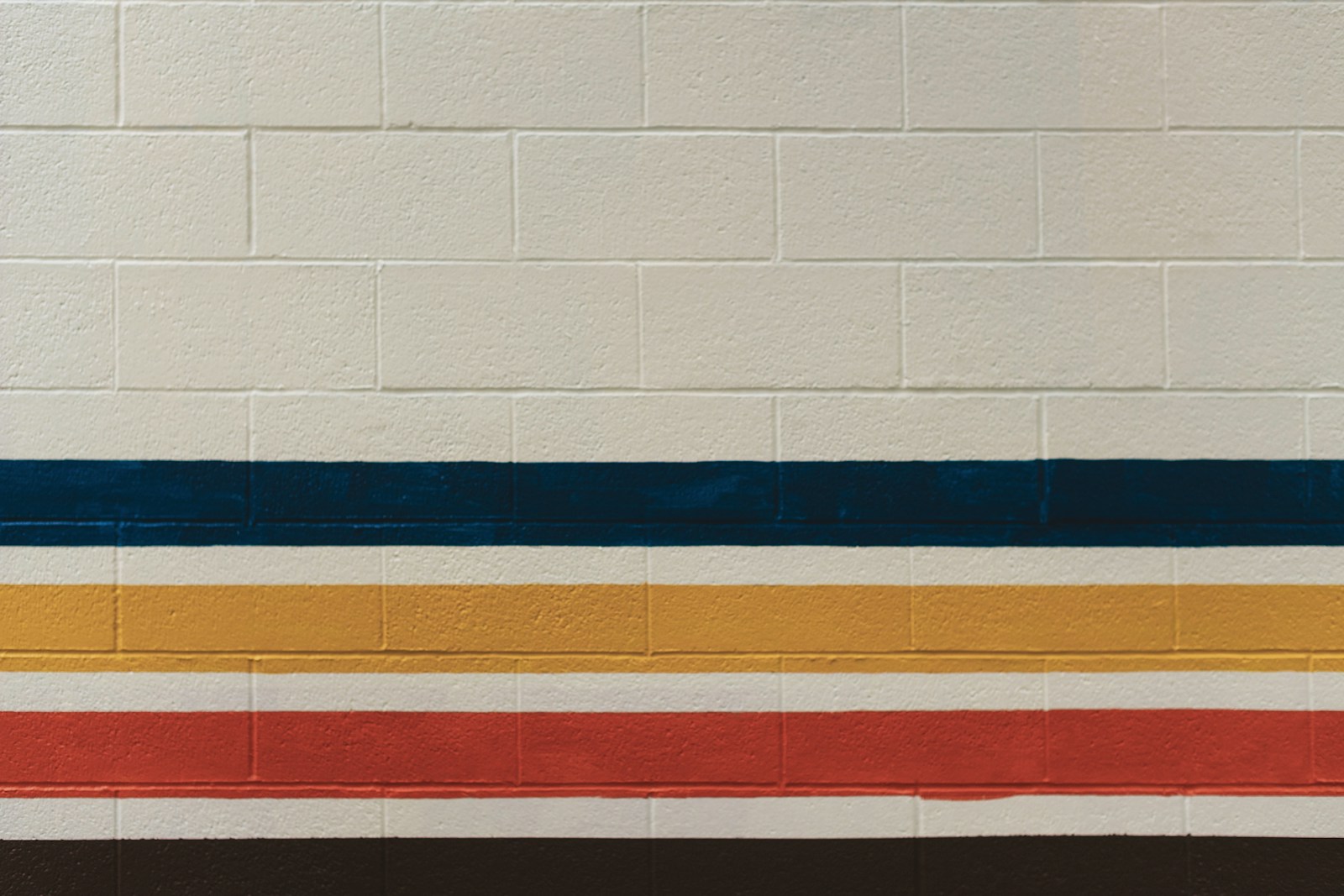 White brick wall with blue, yellow, and red stripes