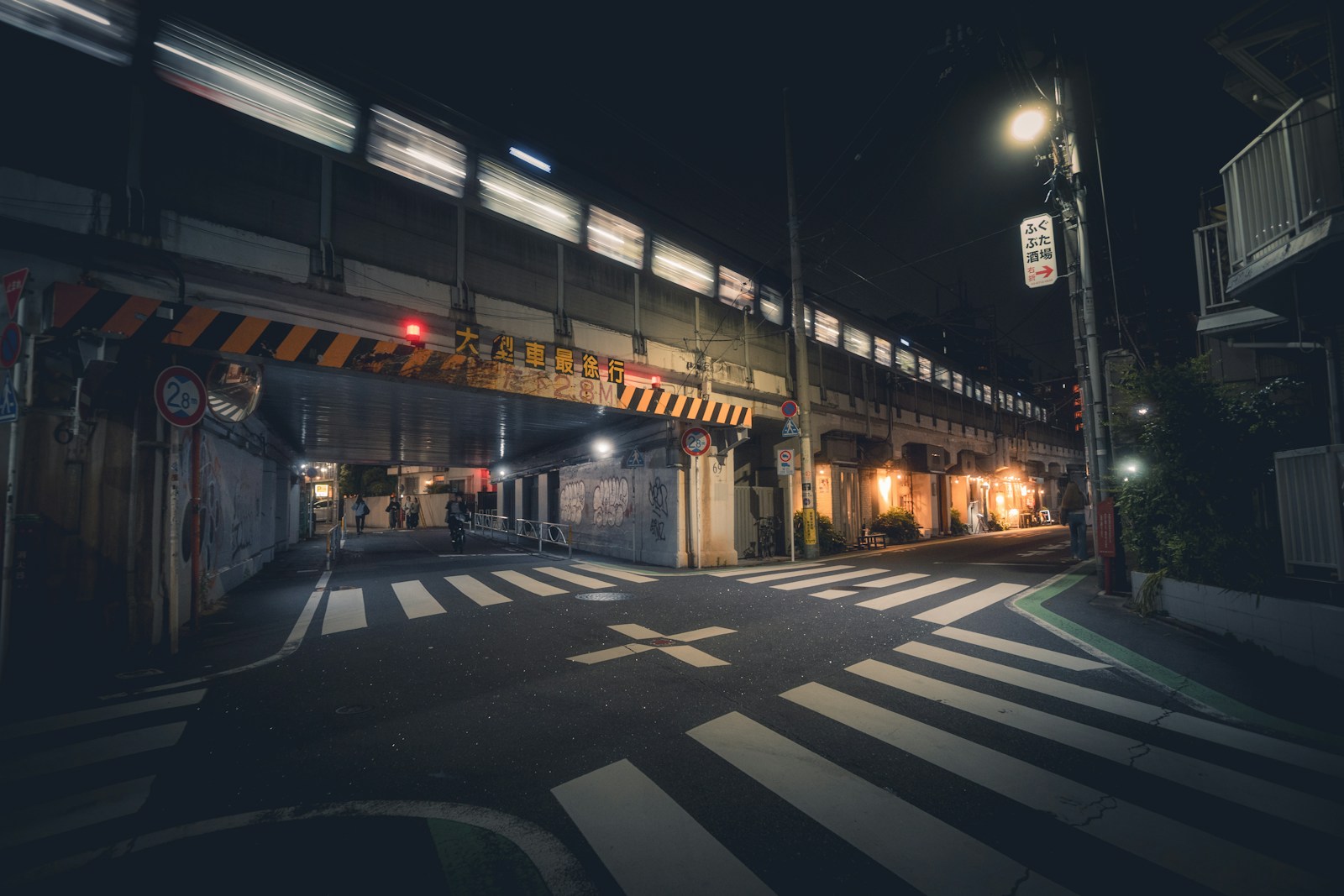 Train passing over a street crossing at night
