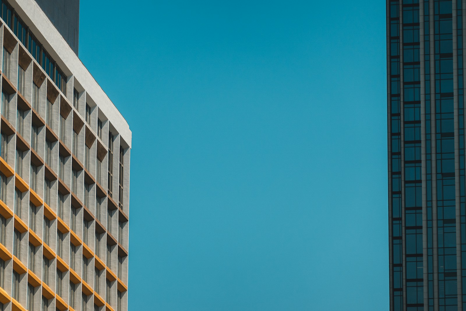 Two modern buildings against a clear blue sky