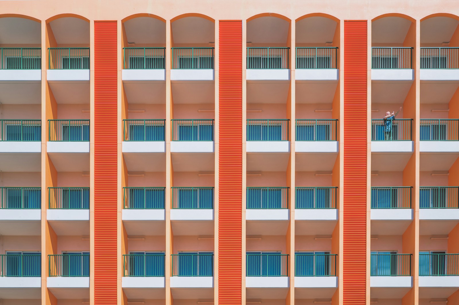 Orange building facade with repeating balconies and windows