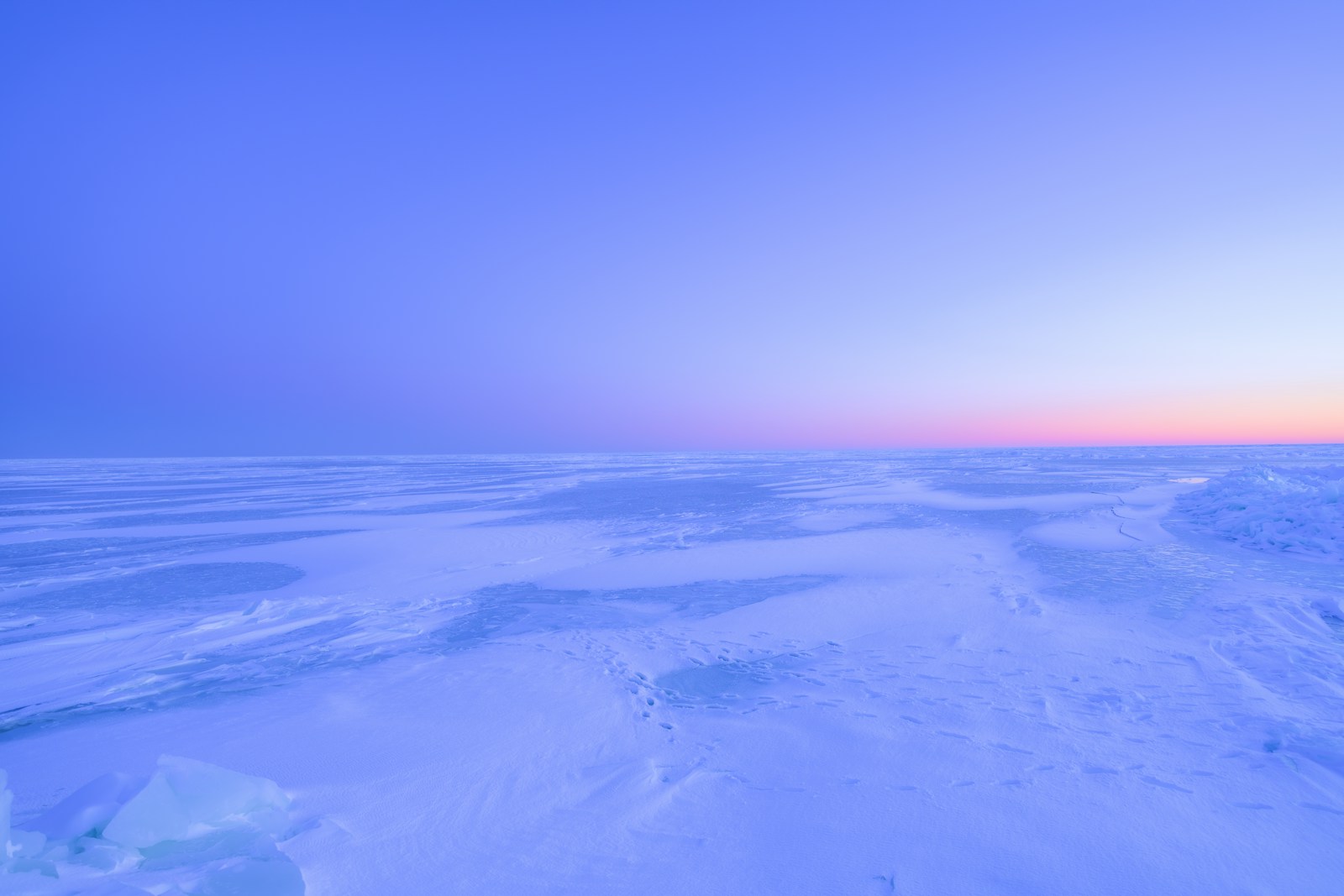 Vast icy plain under a soft blue and pink sky